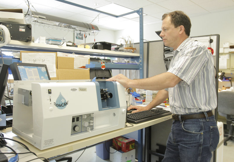 Ilmars Labrencis, an electronics technician at Fluid Imaging Technologies in Yarmouth, upgrades a customer's FlowCAM unit, which takes images of particles in liquids at microscopic levels. Fluid Imaging is expanding from oceanographic research into municipal water testing and industrial uses.