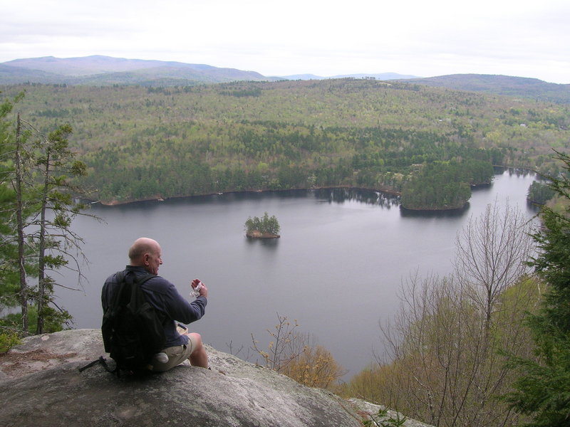 Blaine Mills of Greenwood takes a break overlooking Bryant Pond during a hike on Mount Christopher. A 2-mile loop treats hikers to several clifftop vistas.