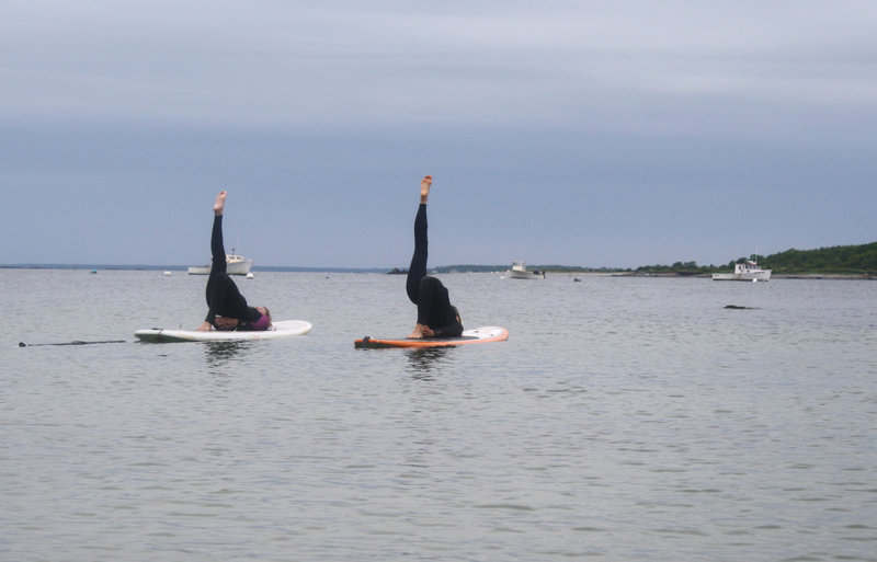 Jill Newel and Brenda Cyr practice SUP "stand-up paddelboard" yoga.