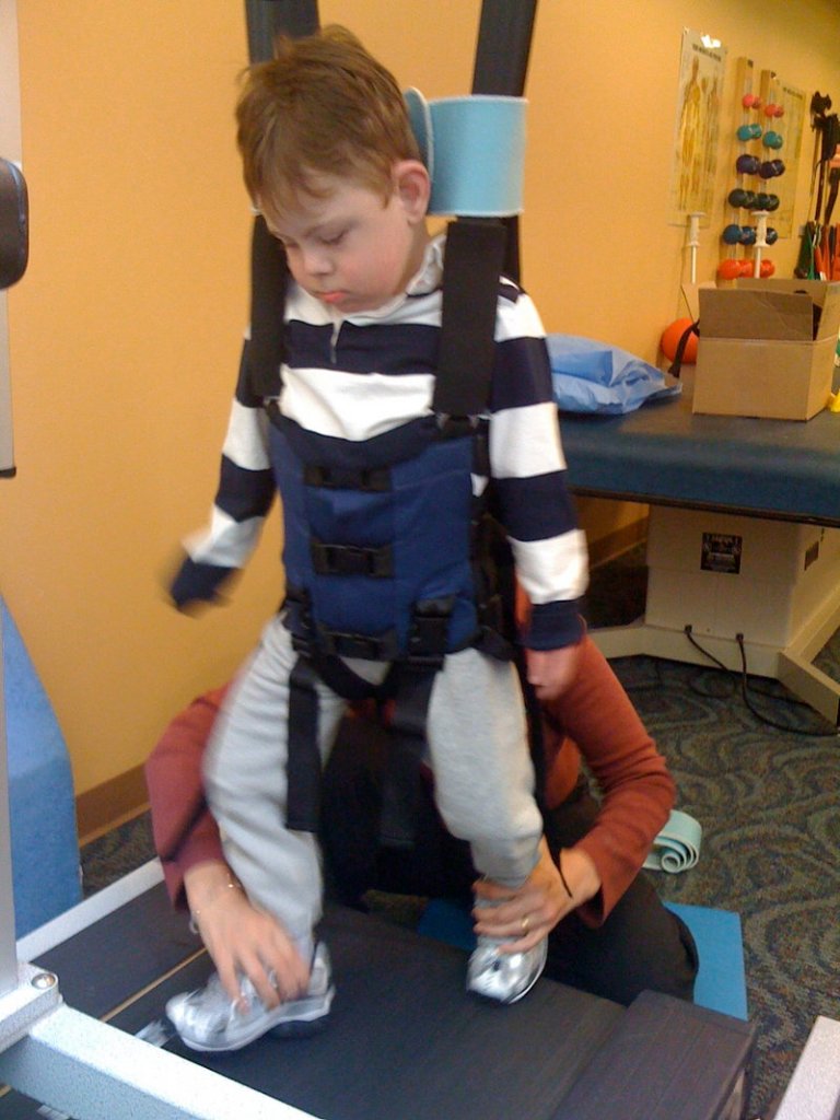Miles Chumsae, a 6-year-old at the Morrison Center in Scarborough, tests a LiteGait trainer during therapy.