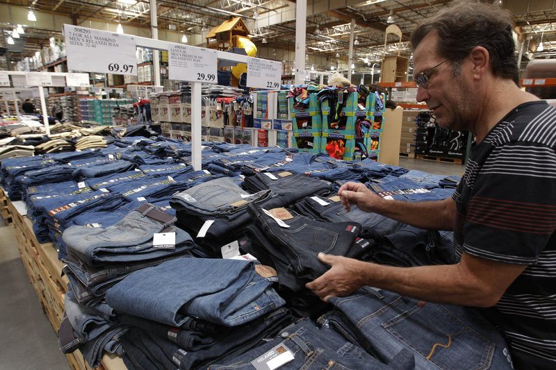 A shopper looks at inexpensive Levi jeans at a Costco in Mountain View, Calif., Monday. Because of the tepid economic recovery, Americans generally tend to be cautious about buying and search more diligently for deals when they do.