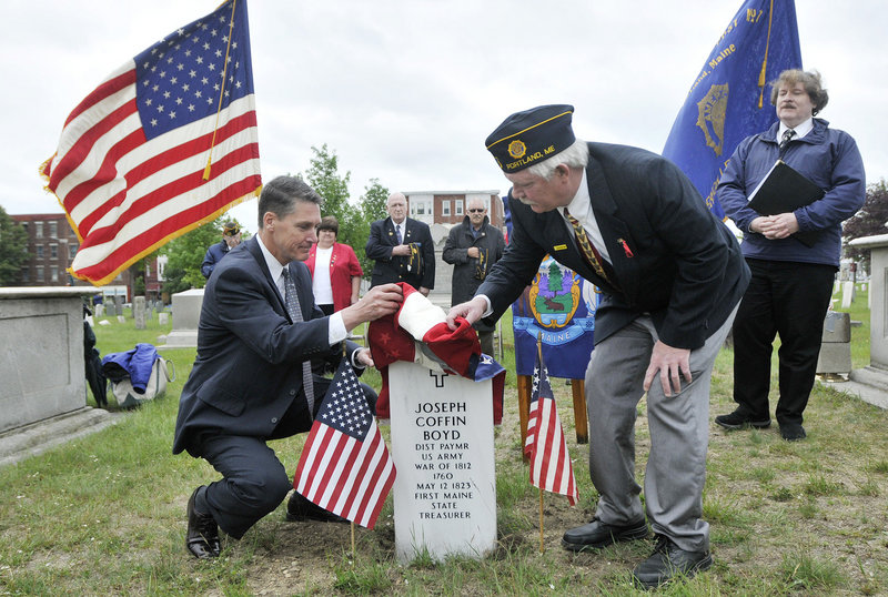 Former state Treasurer David LeMoine, left, and the commander of American Legion Post 17, Curtis Ballantine, unveil the headstone for Joseph Coffin Boyd on Tuesday in Eastern Cemetery. At right is Herb Adams, the historian who worked to obtain the grave marker.