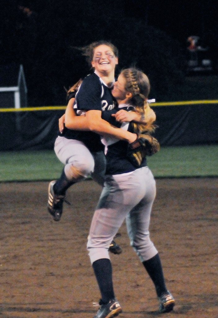 Fryeburg Academy pitcher Sarah Harriman jumps into the arms of first baseman Ashley Watkins after the 6-1 victory against Oak Hill.