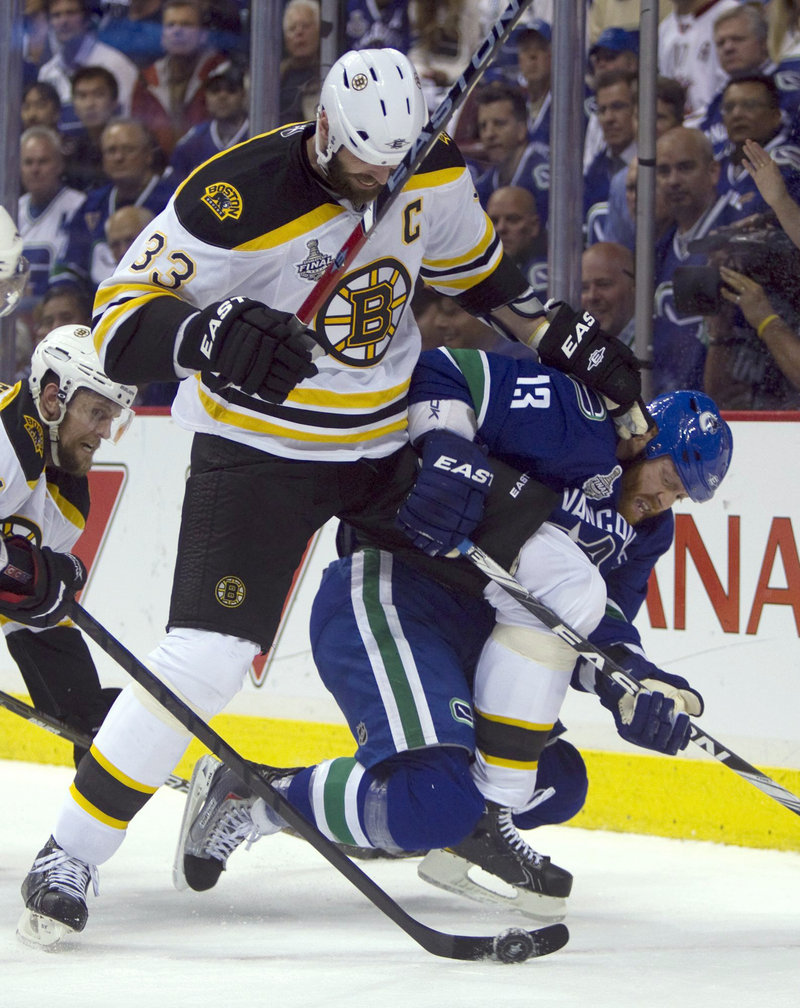 Zdeno Chara of the Boston Bruins takes down Raffi Torres of the Vancouver Canucks in the first period. Chara had a much more important task after the game – accepting the Stanley Cup as the captain of the team.