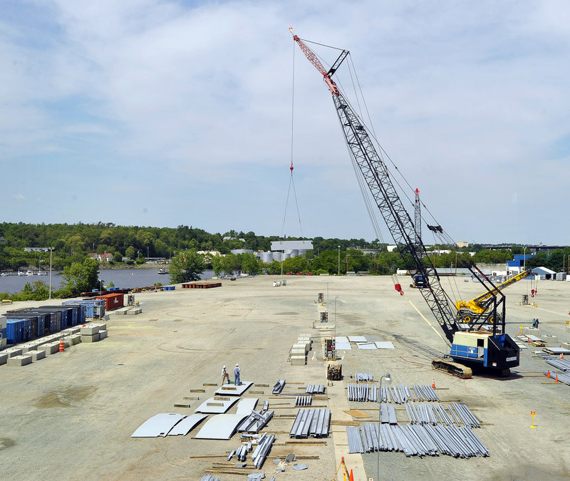 Workers use a large crane to lay out the pieces that will be assembled into 22 modules being built for Vale, a mining company, at the Cianbro site in Brewer.