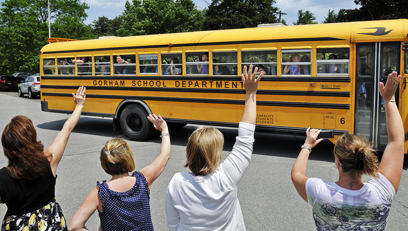 Teachers at White Rock Elementary School in Gorham line up to wave goodbye to students for the last time Friday. The K-2 school closed its doors for good and students will be relocated to a new K-5 school being built on Route 237.