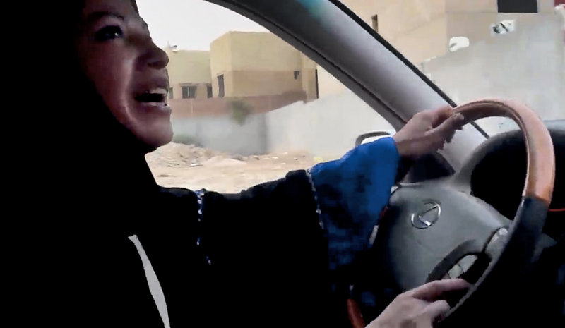 A Saudi Arabian woman drives a car Friday in Riyadh in a campaign to defy the monarchy’s male-only driving rules. About 40 women took part. No arrests were reported, but one woman was ticketed for driving without a license.