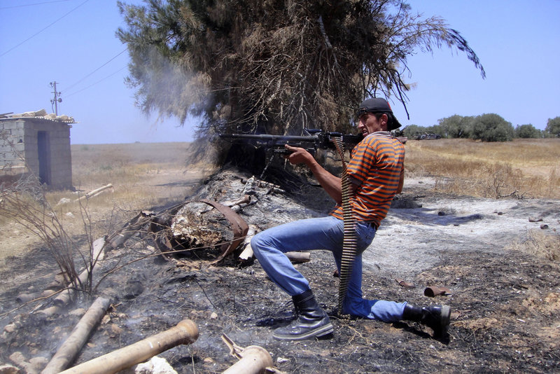 A rebel fighter fires a machine gun toward pro-Gadhafi forces Friday at the front line of Dafniya in Misrata, Libya.