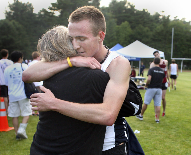 Riley Masters gets a hug from his mother, Alyce, after he placed second in the men's open mile during the Maine Distance Gala.