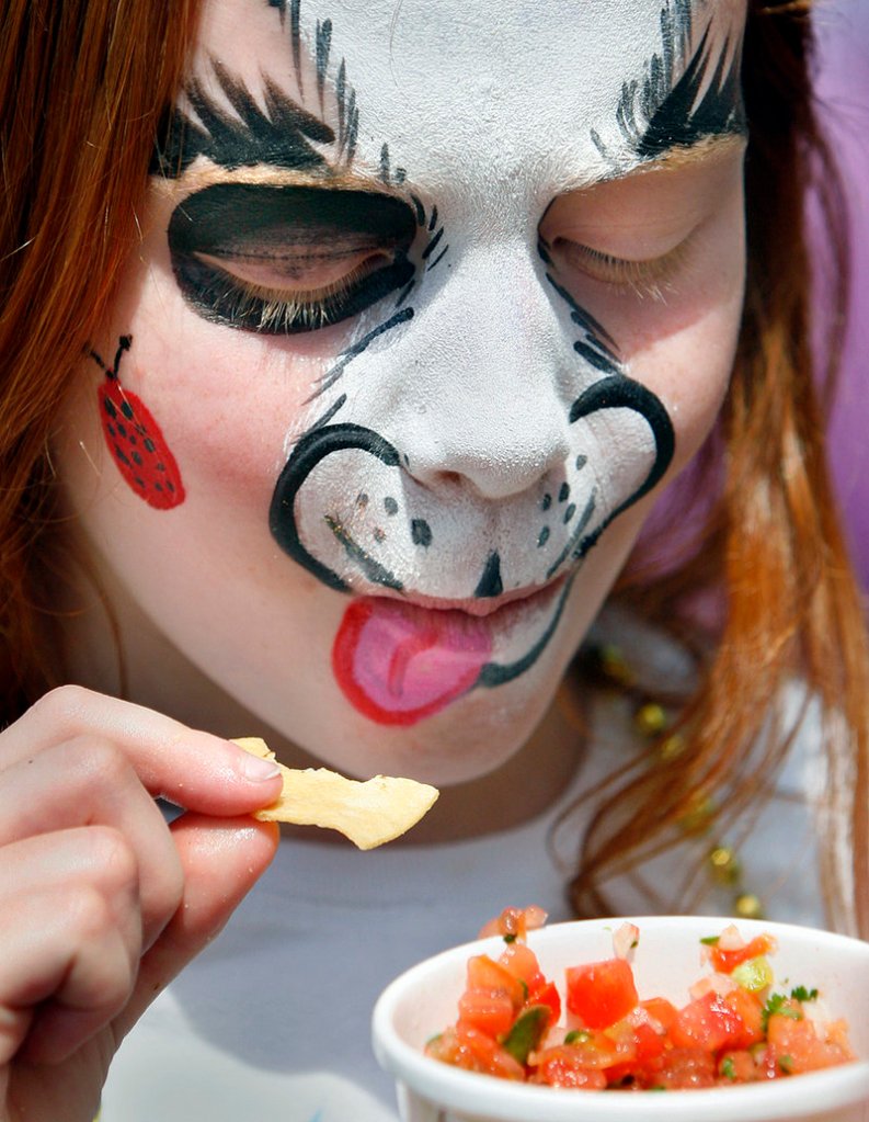 Nichole Roberts, 8, of Kittery got her face painted like a puppy, then enjoyed a snack of chips and salsa.