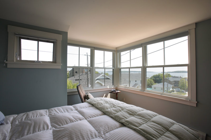 Oversized windows in an upstairs bedroom in the South Portland home of Sharan Townsend provide views of Willard Beach and Casco Bay.