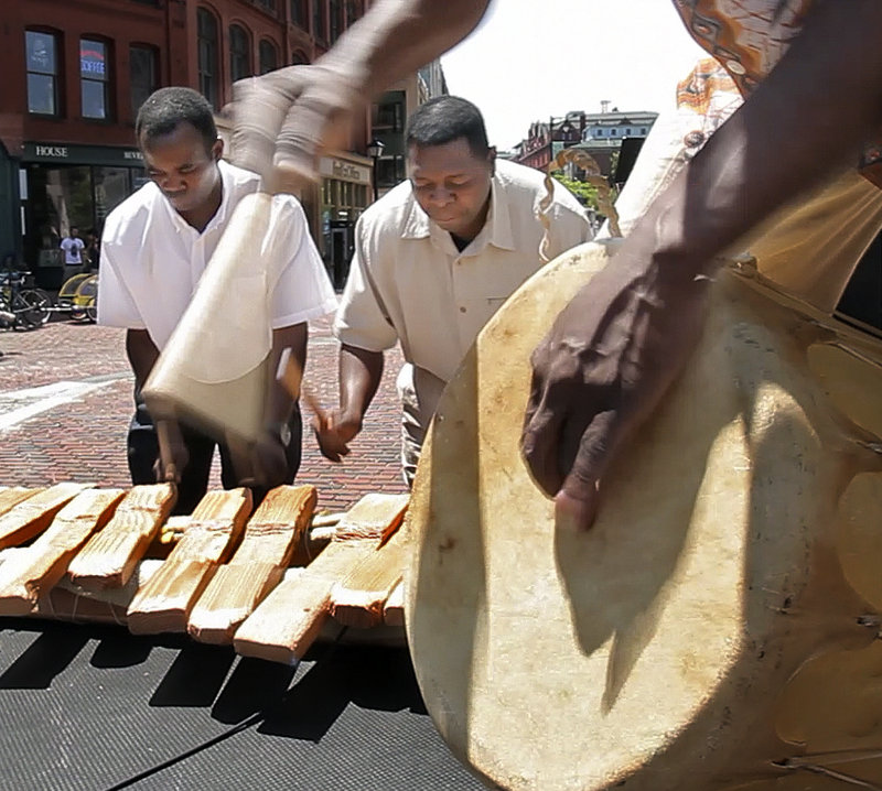 Martin Sungyo, left, and Justin Mokisi play marimbas and William Zungua plays the drum.