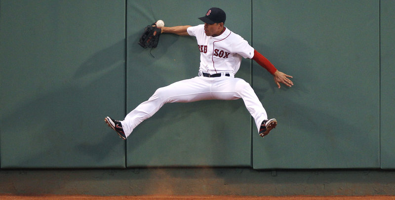 Left fielder Darnell McDonald of the Boston Red Sox slams into the wall while attempting to make the catch on a triple hit by Jesus Guzman of the San Diego Padres in the fourth inning Monday night. The Padres kept the game tight until the Red Sox used a 10-run inning to salt it away.