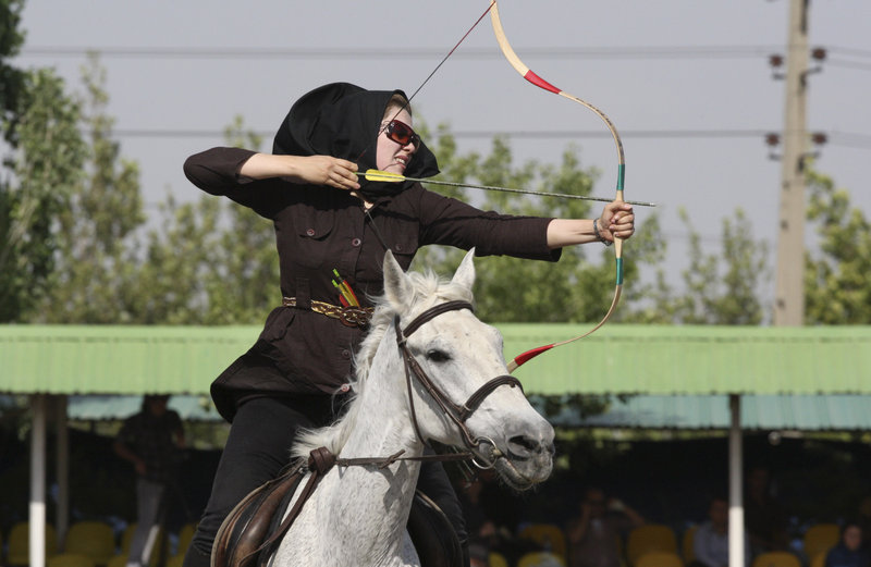 Shiva Mafakheri takes aim during at an archery event in Tehran, where 70,000 police officers have been deployed to enforce codes that ban cropped pants on women and earrings on men.