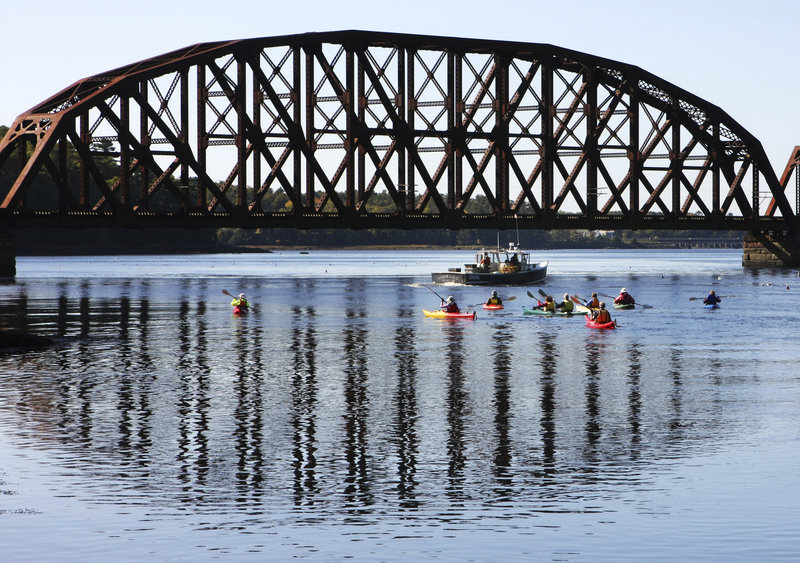 Kayakers on a 2008 Pemaquid Paddlers outing explore the Sheepscot River in Wiscasset as a lobster boat checks traps.