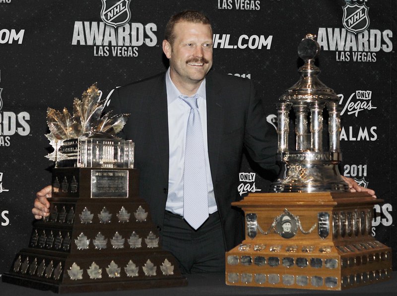 Bruins goalie Tim Thomas shows off his postseason hardware Wednesday: the Conn Smythe Trophy, left, as Stanley Cup MVP, and the Vezina as the NHL’s top goalie.