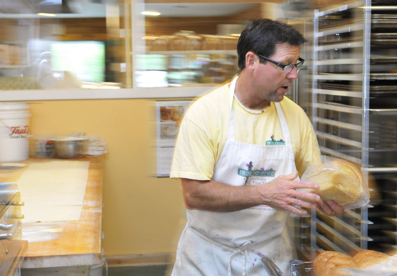 Gari Piscopo stacks loaves of bread in his newly opened bakery at the Highland Avenue Greenhouse and Farm Market in Scarborough.