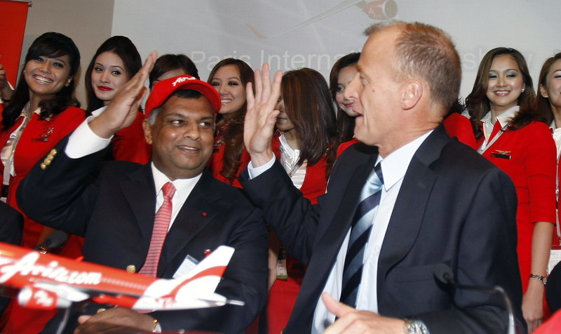 Airbus chief executive officer Tom Enders, right, and AirAsia chief executive officer Tony Fernandes high-five after the signing of an agreement for the sale of 200 Airbus A320neo jetliners during the Paris Air Show on Thursday.