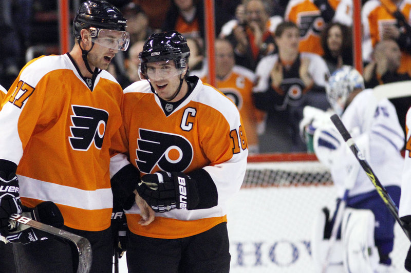 Jeff Carter, left, and Mike Richards are done celebrating as Flyers teammates after Philadelphia dealt them and their big contracts to Columbus and Los Angeles, respectively.