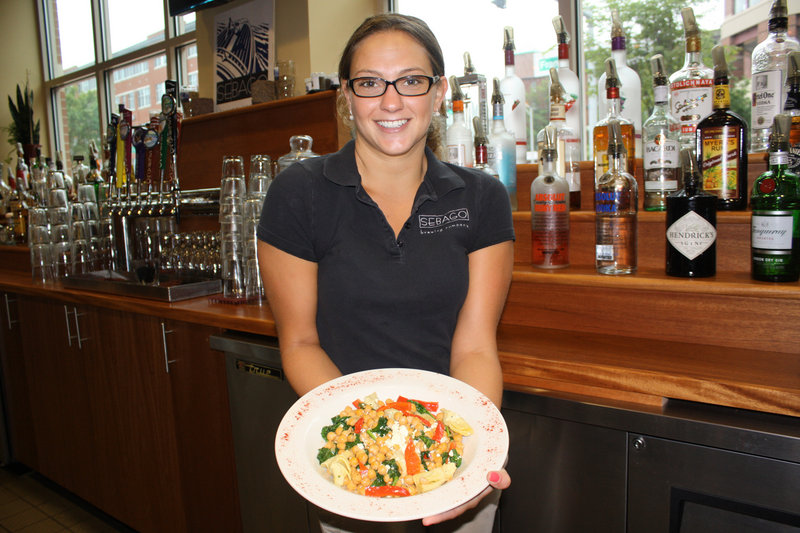 Robyn DiFrancesco, a bartender at Sebago Brewing Co.'s Portland restaurant, serves a warm chickpea salad.