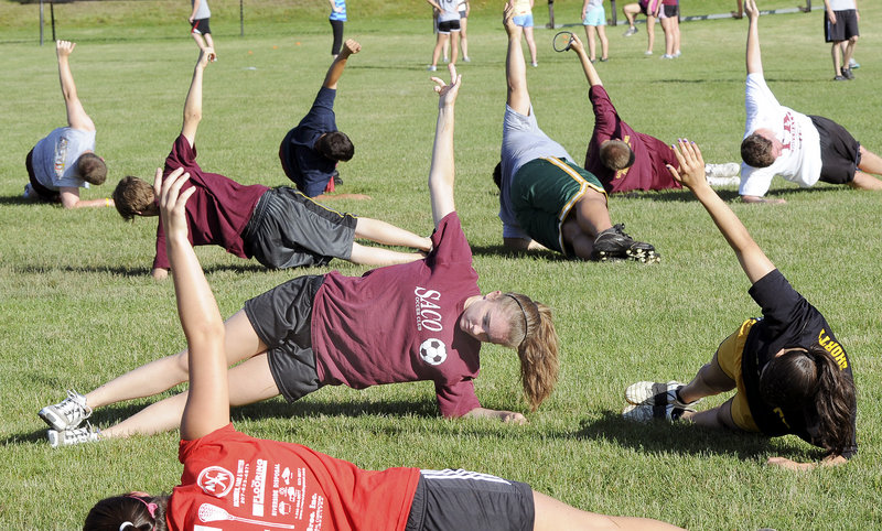 Rick Sirois, the former athletic trainer at Thornton Academy, put together the program with Mike Hersey, an assistant lacrosse coach at the school. Katie McCrum, center, is among students participating in a planks exercise.