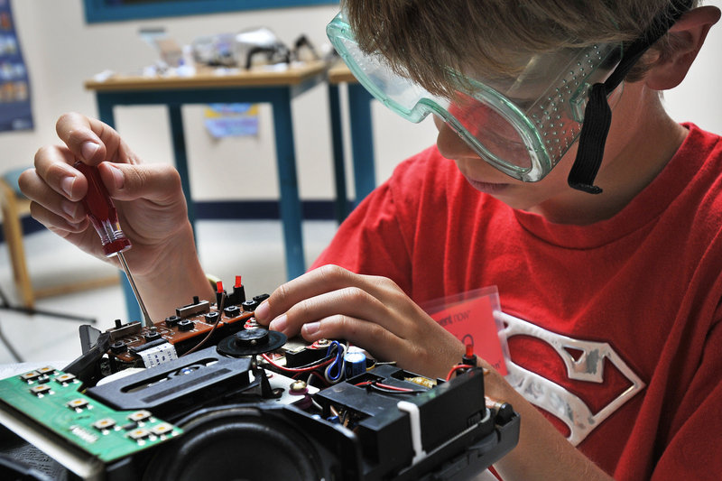 Dain Trafton, 9, of South Portland breaks down part of a computer during Camp Invention at Small Elementary School in South Portland on Monday.