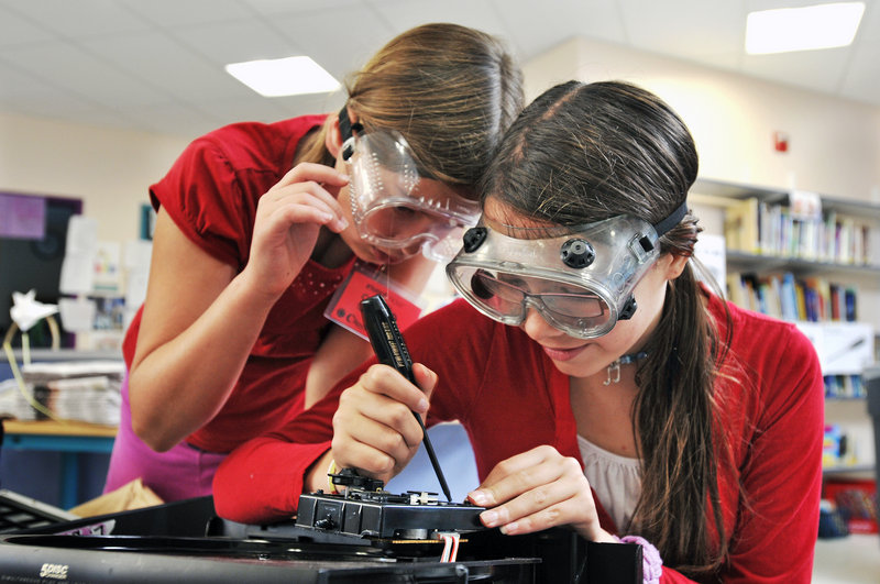 Lilliana Brandao, 11, and Stella Lynch, 11, both of South Portland, work on dissecting electronics during Camp Invention at Small Elementary School in South Portland on Monday. About 60 students are taking part this week.