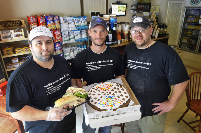 Aaron Plourde, Brian Bailey and Nate Legere of Mediocre Deli in Standish show a ham and Swiss sandwich and a jumbo whoopie pie they call a whooperoni. The deli serves breakfast, lunch and dinner, and takes orders online.