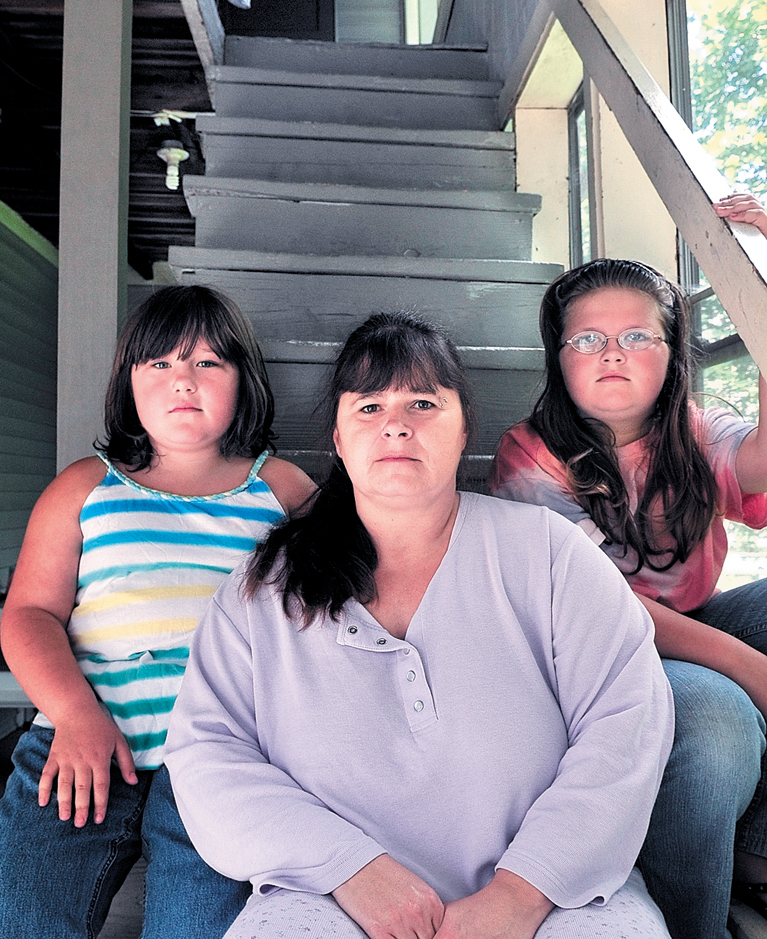 Jennifer Witham and her children, Surae, 10, and Haley, 8, are shown on the stairs of their apartment in Oakland.
