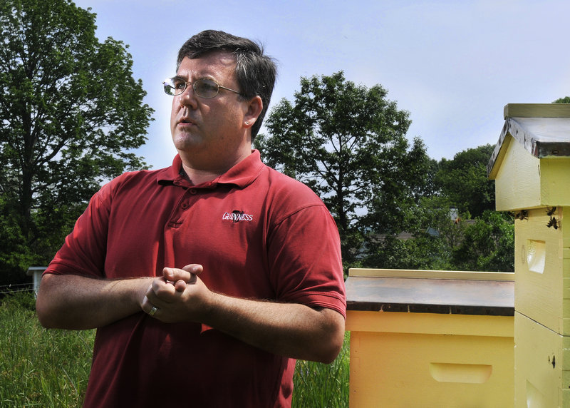 Phil Gaven, standing near two of the four hives he keeps on a friend's property in South Portland on Tuesday, is fighting to change city ordinances that restrict the scope of beekeeping.