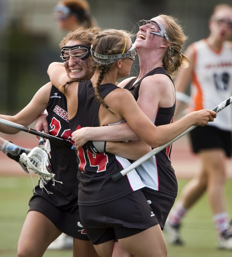 Mary Scott, center, celebrates with Ashley Ronzo, left, and Maggie Smith after scoring the goal that gave Scarborough a 12-8 lead against Brunswick on the way to a 13-11 victory in the Class A girls’ lacrosse final.