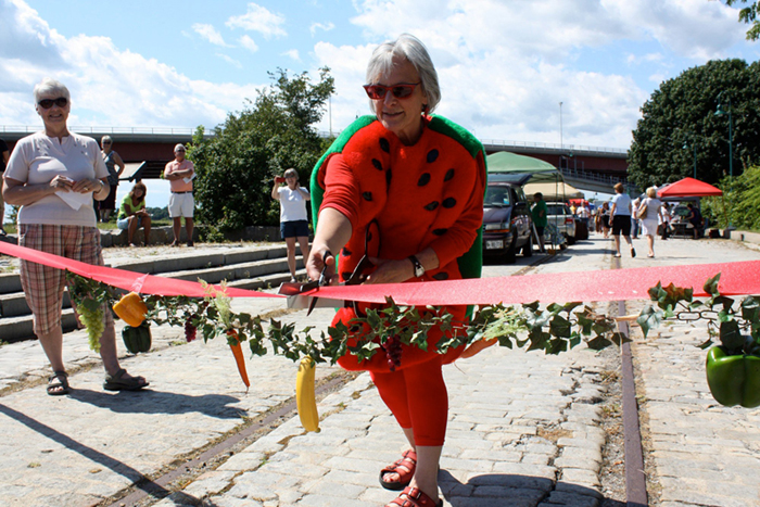Dressed as a watermelon, South Portland Mayor Rosemarie De Angelis cuts the ribbon at the opening of the first South Portland Farmers Market.