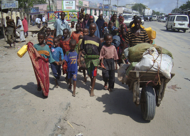 Refugees from southern Somalia carry their belongings as they make their way to a new camp for internally displaced people in Mogadishu on Thursday.