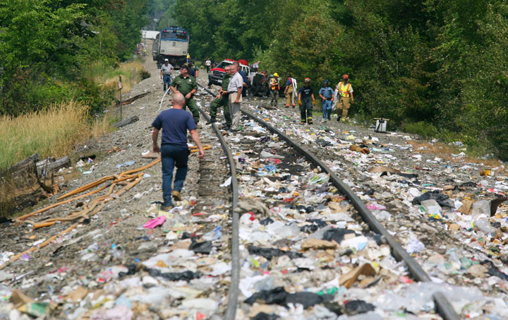 Emergency responders work amid trash strewn along the tracks in North Berwick where the Downeaster struck a trash-hauling tractor-trailer. The truck's driver was killed.