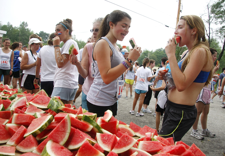 Logan Davis, center, and Jessica Hoffman, right, both campers at Forest Acres Camp in Fryeburg, enjoy watermelon after finishing the 4 on the Fourth race.