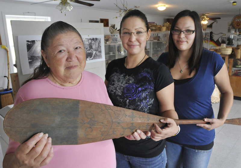 Descendants of famous Passamaquoddy chief Tomah Joseph, from left, Joan Dana, Natalie Dana and Cassandra Dana show off a paddle made by Joseph and on display at the Passamaquoddy Cultural Heritage Center & Museum in Indian Township.