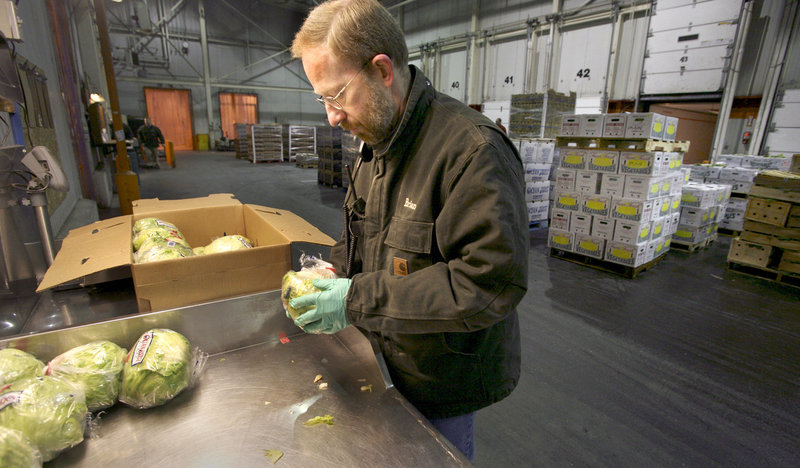 Brian Smith checks the quality and condition of lettuce at the produce dock at the Hannaford distribution center in South Portland.