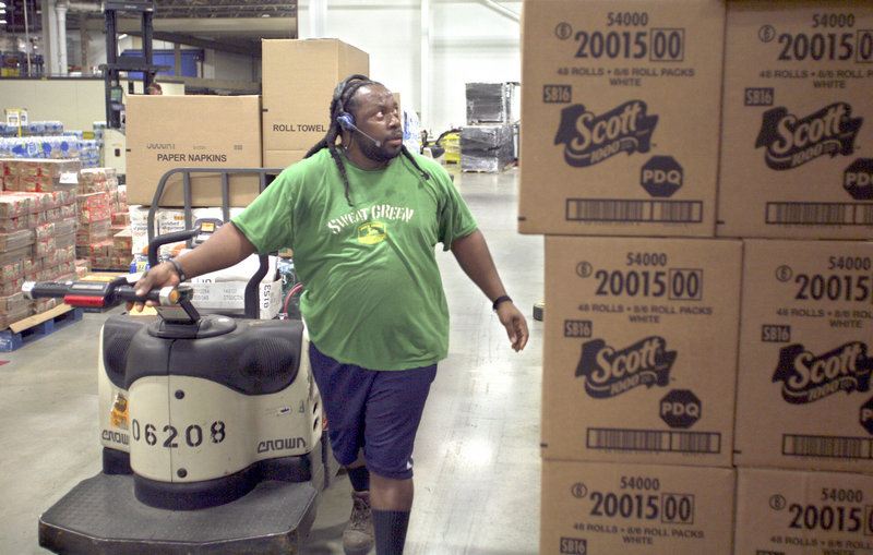 Marvin Lindsay listens through a headset for instructions on which products to load on a jack at the distribution center.