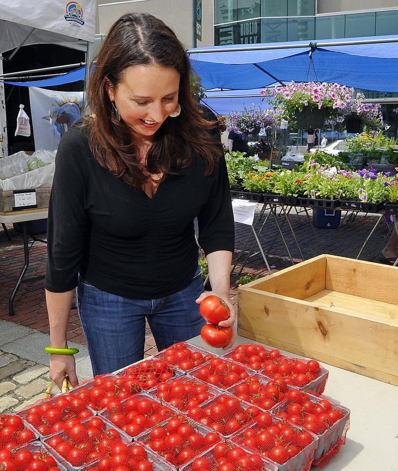 Stephanie Hedlund shops for tomatoes at the Olivia’s Garden table at the Portland Farmers Market in Monument Square.