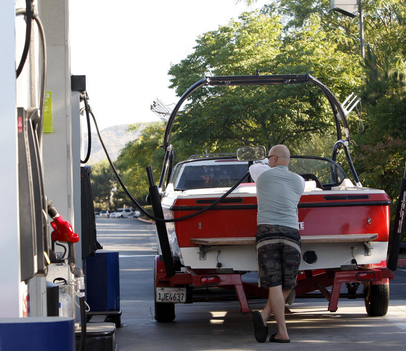 A motorist buys gas for his boat, getting an early start on holiday weekend traffic Friday in Burbank, Calif.