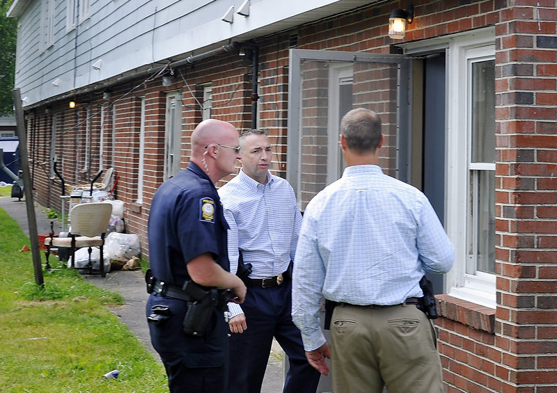Assistant Police Chief Michael Sauschuck, center, talks with Officer Mark Kezal, left, and Lt. Gary Rogers, head of the Special Reaction Team that responded to the Riverton Apartments on Friday.