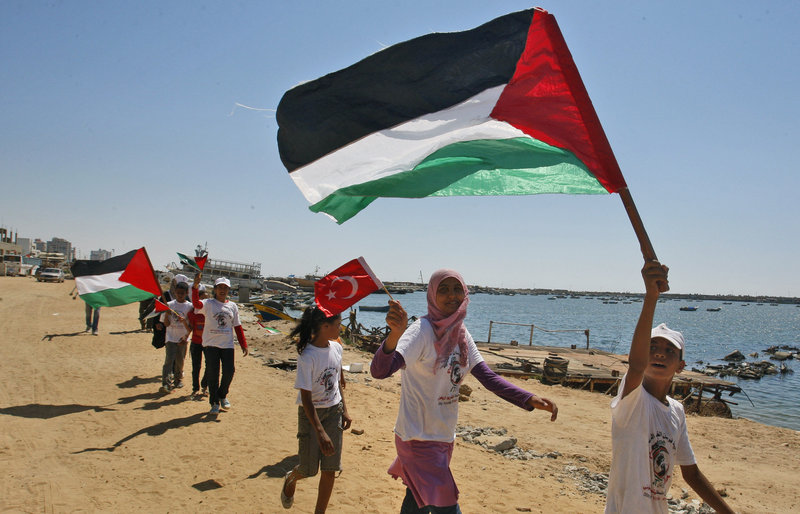 Palestinian children fly Palestinian and Turkish flags in the port of Gaza City on Saturday to show their support for the flotilla that is attempting to reach the Gaza Strip.