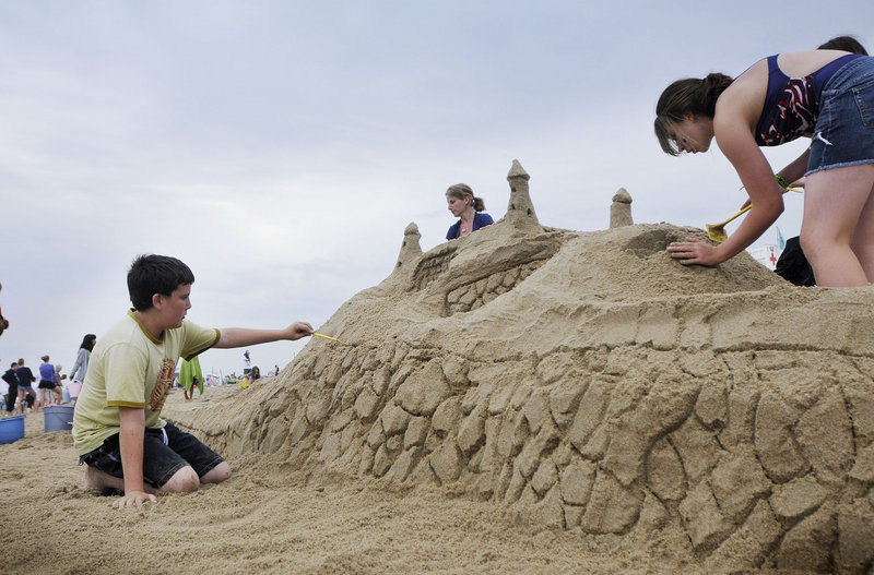 Left to right, Connor Stevens, 13, of Albany N.Y., Laura Bickford and Danielle Bickford, 14, both of Kennebunk, work on their team's sculpture during the competition in Ocean Park on Sunday.
