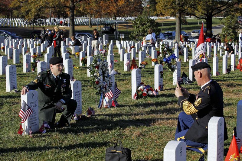 Command Sgt. Maj. Jeff Mellinger, right, photographs Sgt. Timothy Weicher of Rockville, Md., next to the grave of Robin Towns Sr. at Arlington National Cemetery last Veterans Day.