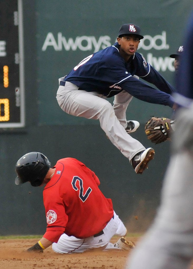 Jeremy Hazelbaker of the Portland Sea Dogs slides hard Sunday night but fails to stop Justin Jackson of the New Hampshire Fisher Cats from getting the throw to first base for a double play.