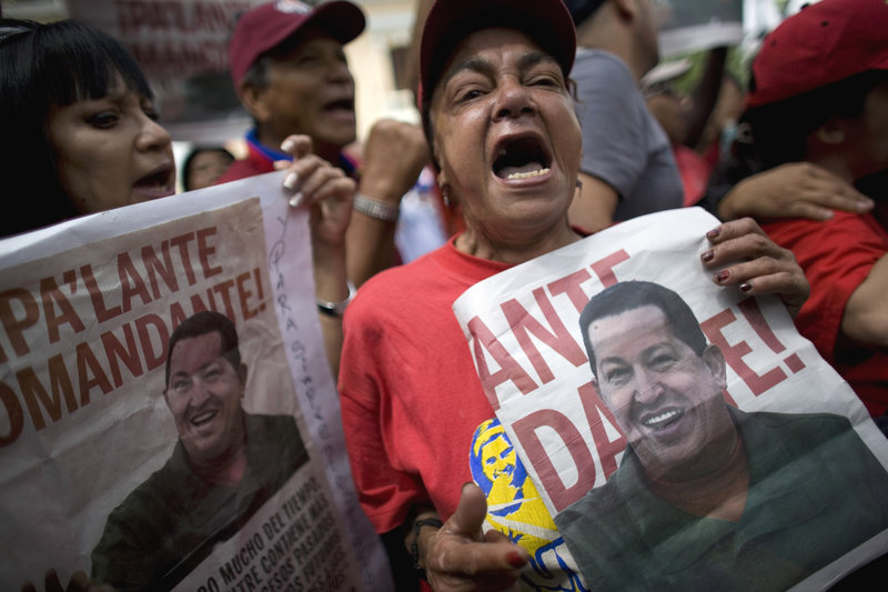 Supporters celebrate the return of Venezuela’s President Hugo Chavez in Caracas, Venezuela, on Monday, holding posters bearing his image that read in Spanish: “Moving forward Commander.” Chavez returned Monday after undergoing cancer treatment in Cuba.