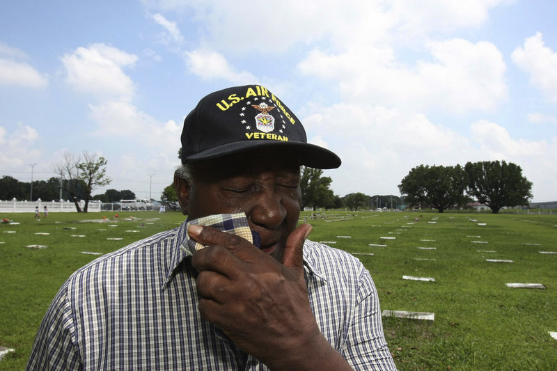 Retired Air Force Tech. Sgt. Littleton J. Fortune wipes his tears after praying at the grave of his son, U.S. Army Sgt. Maurice Keith Fortune, who was killed in the war in Iraq, after attending the burial of a comrade at Clark Veterans Cemetery in the Philippines.