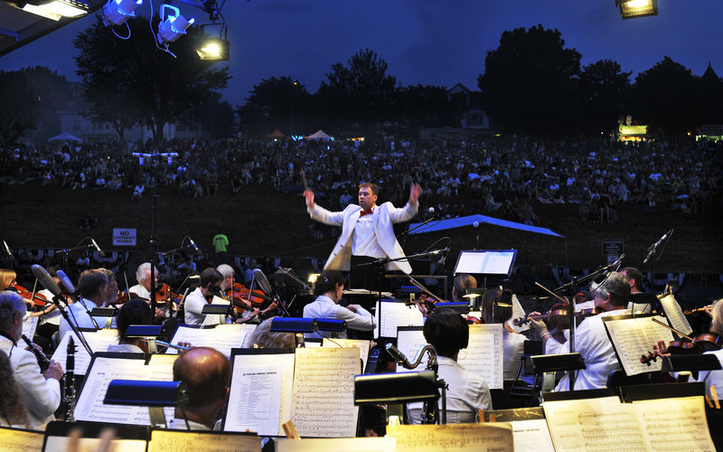 The Portland Symphony Orchestra, conducted by Robert Moody, performs on the Eastern Prom on Monday. Tenor Paul Baswell accompanied the orchestra, which entertained crowds before the fireworks display after dusk.