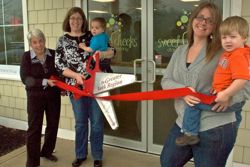 Karen Osper, left, owner of Sweet Cheeks Diaper Co., joins manager Leslie Reichert, right, and a couple of their clients at a ribbon-cutting ceremony at the store on Market Place Drive in York.