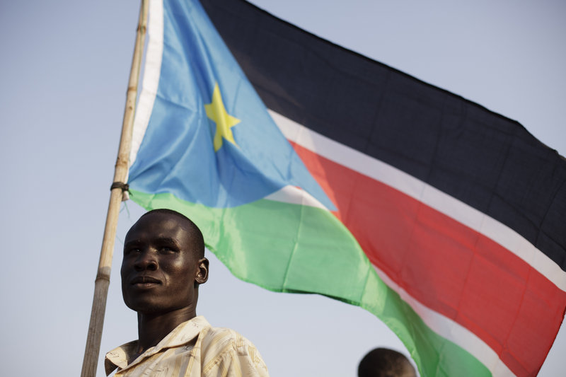 A Bari community member holds the flag of South Sudan on Friday in the capital of Juba, during celebrations anticipating today s declaration of independence. The city is sprucing itself up for the occasion, and beefed-up security forces are patrolling to prevent violence.